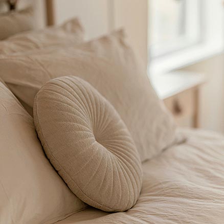 photo montrant un coussin beige sur une tête de lit